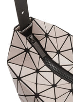 Close-up of the VALLEY handbag by BAO BAO ISSEY MIYAKE, featuring beige and black geometric panels, a gusseted design for stability, black zipper and strap. The zipper pull is engraved with the brand name.