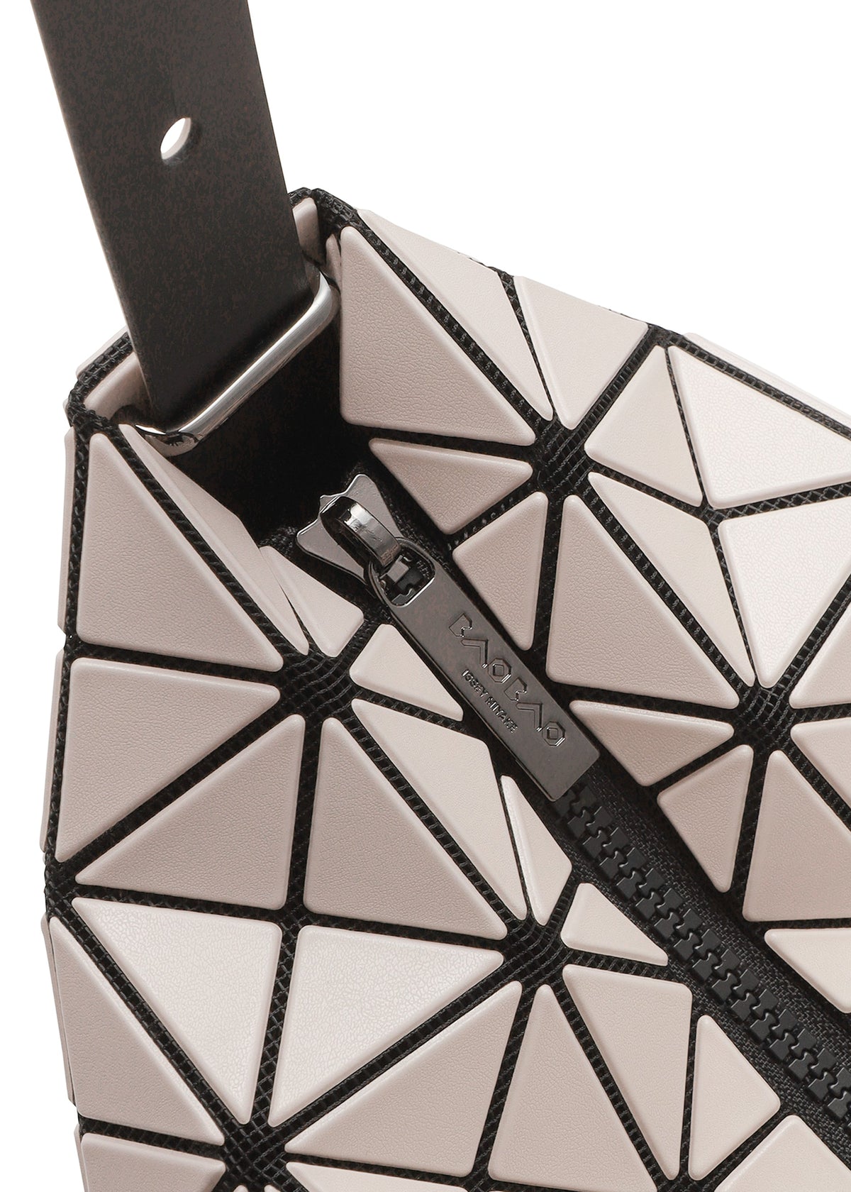 Close-up of VALLEY by BAO BAO ISSEY MIYAKE, a geometric gusseted handbag with glossy light triangles outlined in black, triangular panels, visible zipper, and a black strap attached by a metal loop at the corner. view 4 of 6