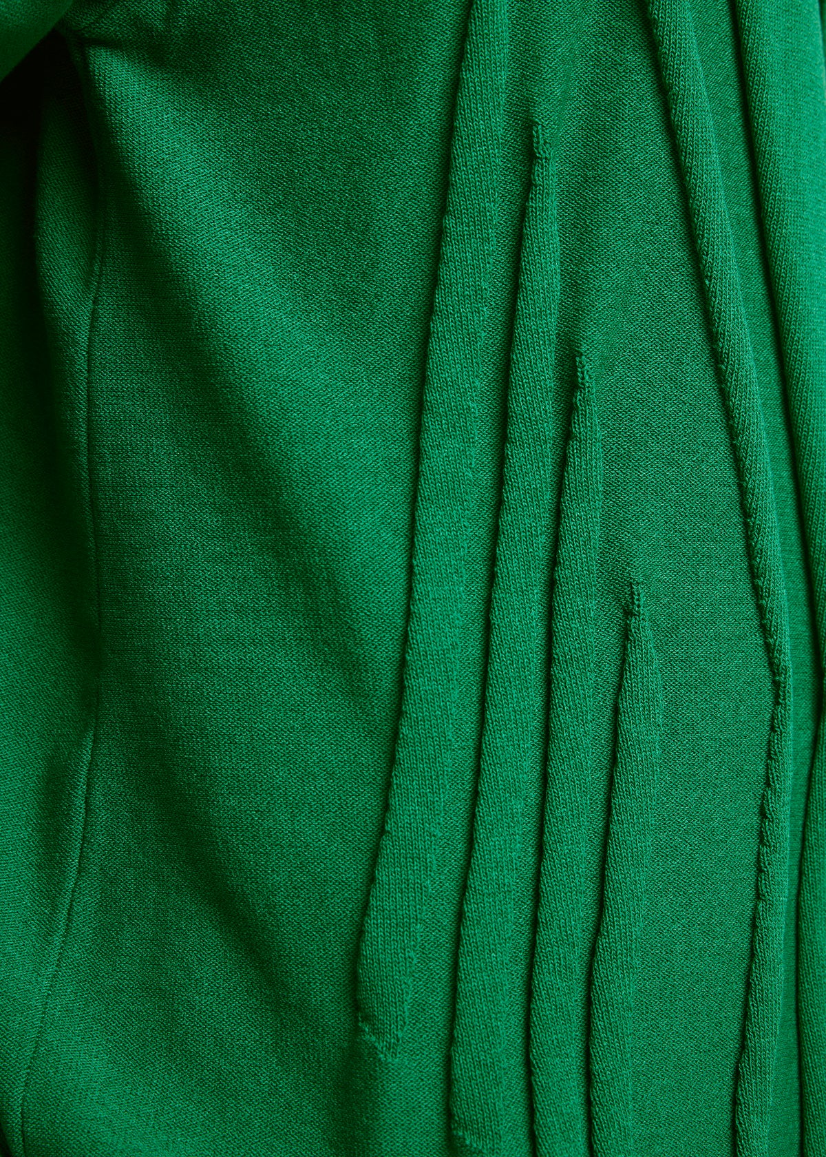 Close-up of green TYPE-K 003-1 fabric by A-POC ABLE ISSEY MIYAKE, showing vertical slits with frayed edges and soft, textured surface—a result of Steam Stretch’s unique three-dimensional knitting technique. view 4 of 7