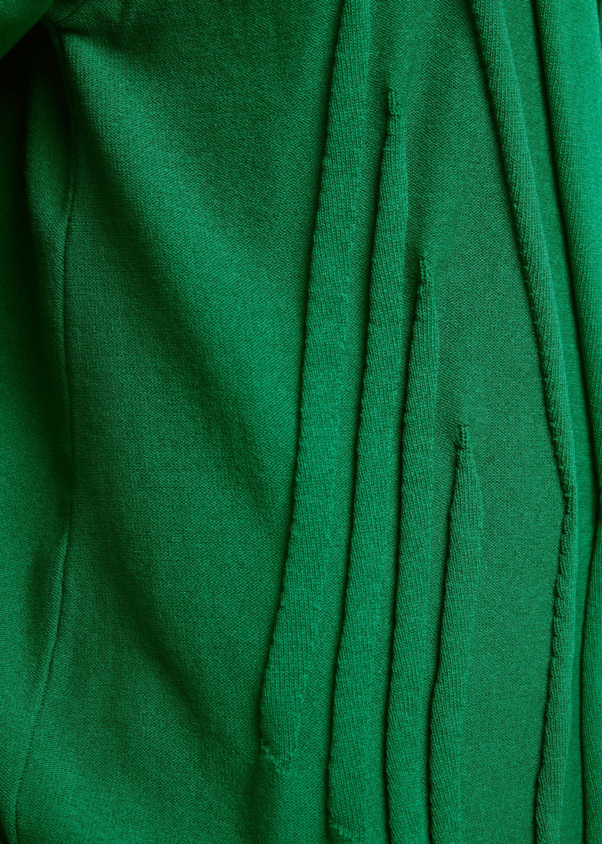 Zoomed view Close-up of green TYPE-K 003-1 fabric by A-POC ABLE ISSEY MIYAKE, showing vertical slits with frayed edges and soft, textured surface—a result of Steam Stretch’s unique three-dimensional knitting technique.