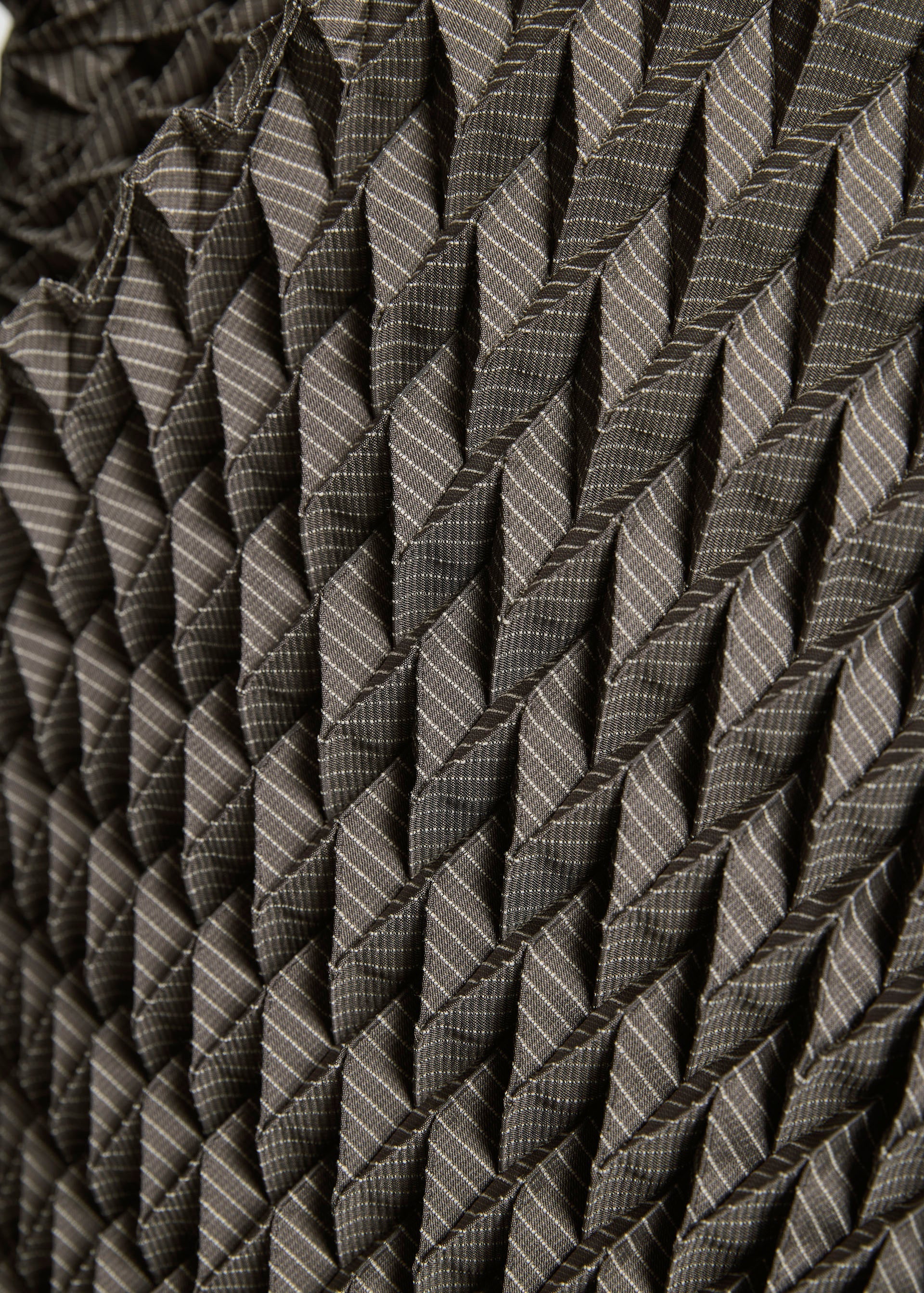 Zoomed view Close-up of the TYPE-O STOLE by A-POC ABLE ISSEY MIYAKE, showcasing its geometric 3D pleated pattern in grey tones with textured folds and bold diagonal lines.