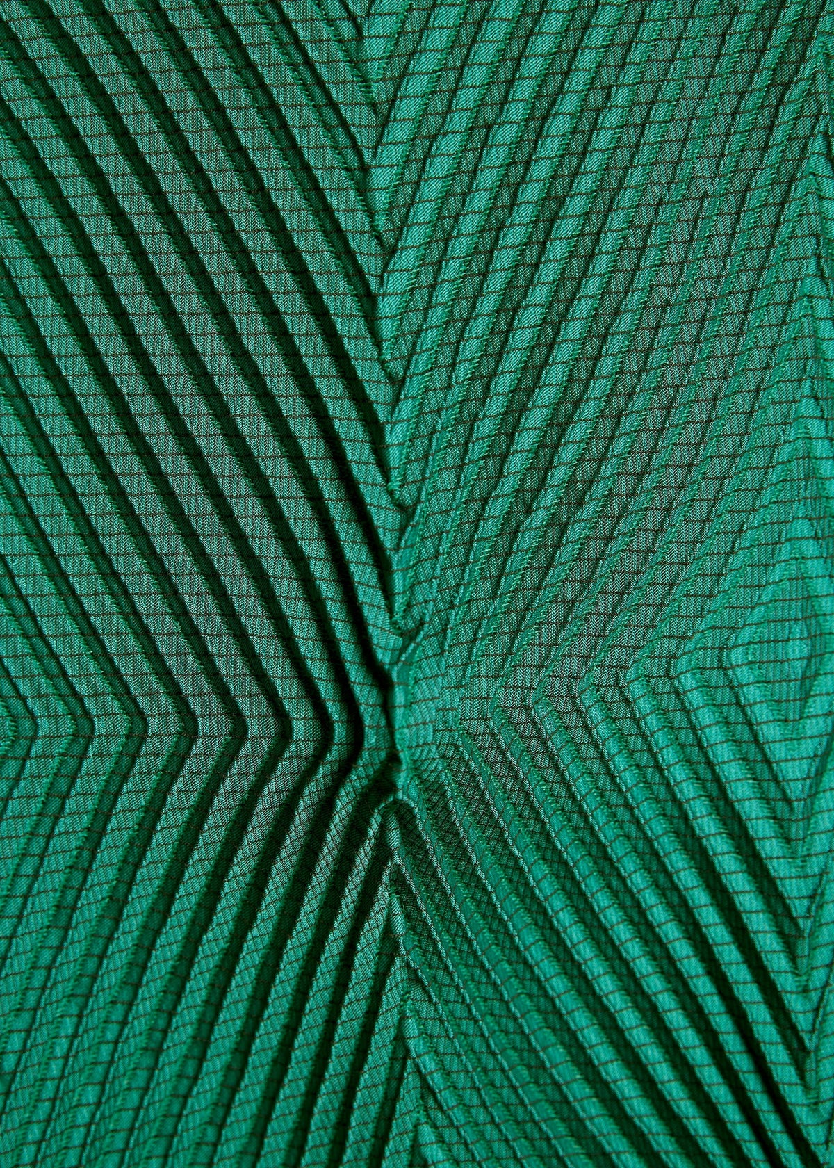 Close-up of TYPE-O 007 by A-POC ABLE ISSEY MIYAKE: green recycled polyester pants fabric with a geometric zigzag pattern and textured, raised chevron lines across the surface. view 9 of 10