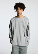 A person with short, curly hair models the TYPE-C 003 loose light gray striped long-sleeve shirt and matching cotton pants by A-POC ABLE ISSEY MIYAKE, standing against a plain light background.