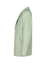 TYPE-U 001 by A-POC ABLE ISSEY MIYAKE is a light green casual blazer displayed from the side on a white background, featuring notched lapels, side pockets, and a relaxed fit for effortless comfort. This shape-memory, wrinkle-resistant jacket keeps you looking sharp all day long.