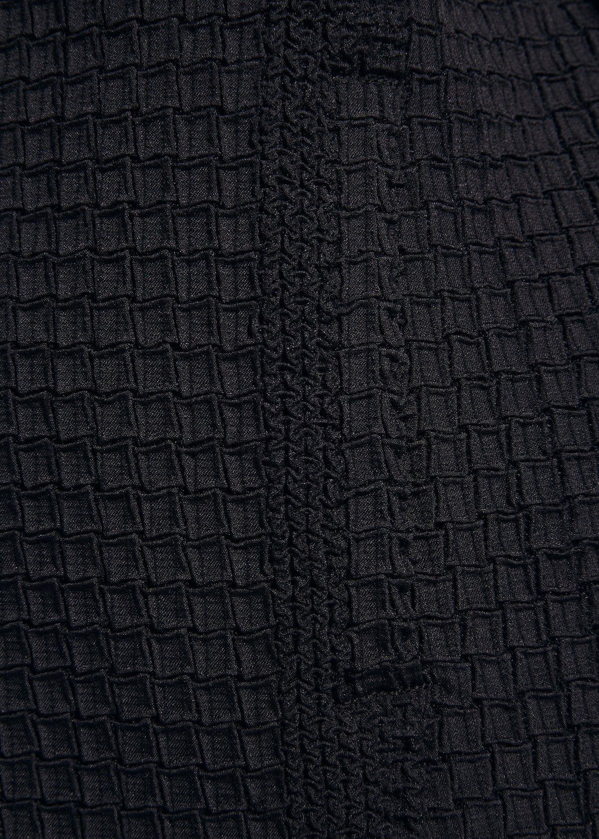 Close-up of TYPE-O 014 by A-POC ABLE ISSEY MIYAKE—black fabric with textured, grid-shaped pleats and a vertical woven seam, ideal for detailed accents on a tailored collar jacket. view 8 of 8