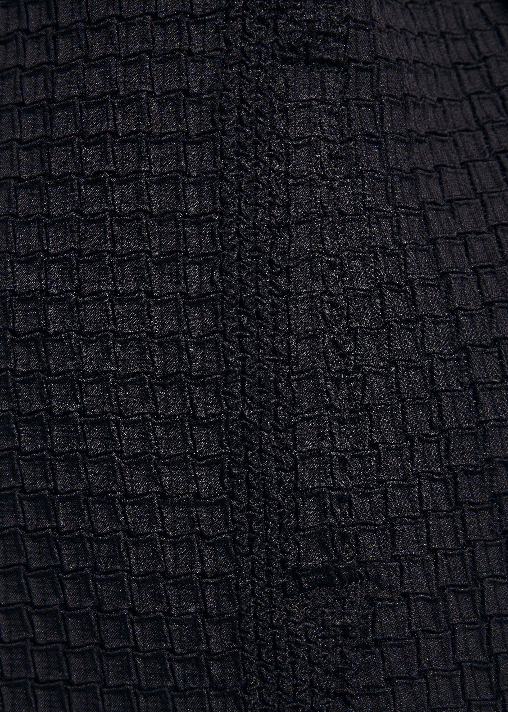 Zoomed view Close-up of TYPE-O 014 by A-POC ABLE ISSEY MIYAKE: textured black fabric with grid-shaped pleats and a vertical woven strip—ideal for tailored or stretch jackets.