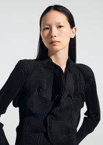 A person with long, straight dark hair models the TYPE-O 022 jacket by A-POC ABLE ISSEY MIYAKE—featuring a high collar and geometric patterns—standing against a plain light background and looking confidently at the camera.