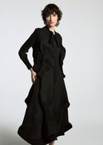 A person with short curly hair wears the TYPE-Ⅰ 008 dress by A-POC ABLE ISSEY MIYAKE and a sleek Steam Stretch jacket, standing against a plain light background.