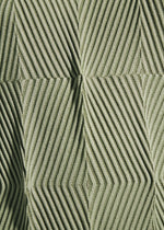 Close-up of a textured green surface with repeating diamond and triangle patterns formed by raised, diagonal lines, reminiscent of the innovative fabric featured in TYPE-W 009-2 pants from A-POC ABLE ISSEY MIYAKE.