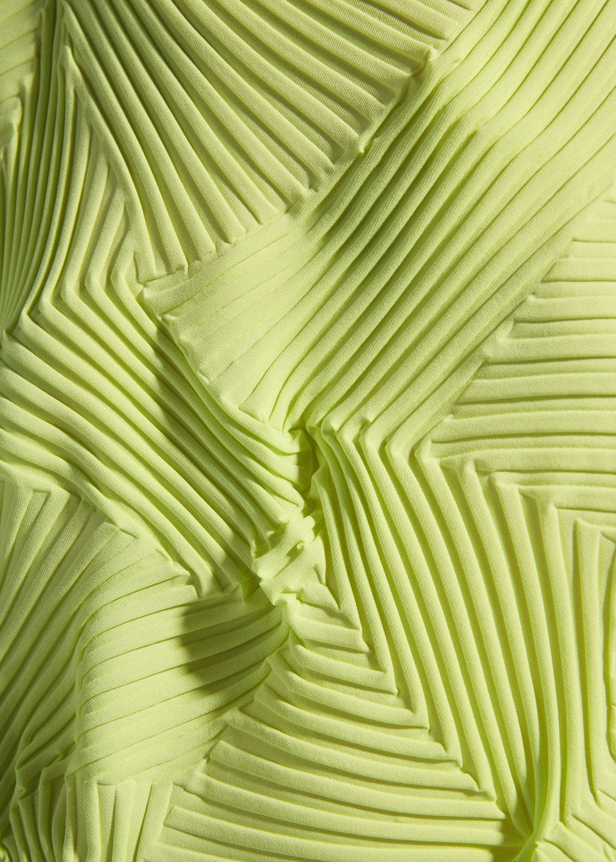 Close-up of TYPE-P 003-2 by A-POC ABLE ISSEY MIYAKE: yellow-green fabric with Baked Stretch technique, featuring geometric pleats and zigzag patterns that create a dynamic three-dimensional effect. view 8 of 9