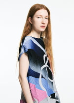 A person with long red hair stands against a white background, wearing the TYPE-XV SOAR NY project 001 dress by A-POC ABLE ISSEY MIYAKE, featuring geometric patterns and subtle pleats, gazing thoughtfully past the camera.