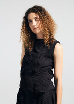 A person with curly brown hair wears the sleeveless, textured TYPE-P 003-2 dress by A-POC ABLE ISSEY MIYAKE, crafted with the Baked Stretch technique, standing against a plain background—ideal for versatile everyday wear.