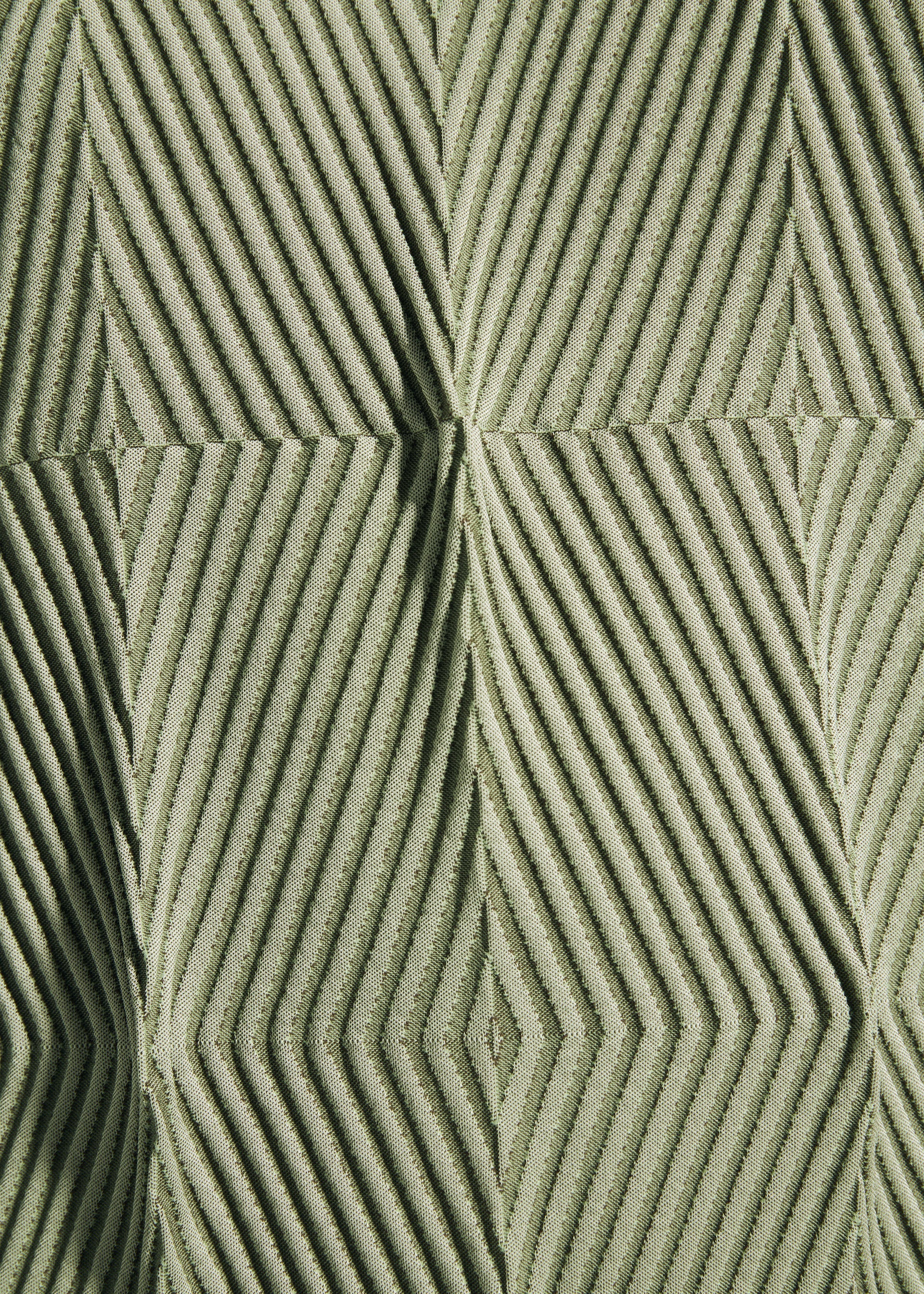 Zoomed view Close-up of a textured surface with a geometric pattern of raised, diagonal lines forming diamond and triangle shapes in light green fabric, reminiscent of the subtle detailing found on the TYPE-W 009-2 by A-POC ABLE ISSEY MIYAKE, crafted from stretchy polyester.