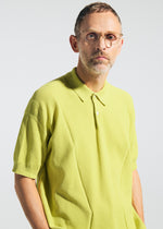 A man with short hair, glasses, and a trimmed beard wears the TYPE-K 003-2 knit polo shirt by A-POC ABLE ISSEY MIYAKE, looking at the camera against a plain light background.