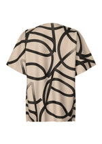 TYPE-XV SOAR NY project 002 by A-POC ABLE ISSEY MIYAKE is a short-sleeved beige shirt with a bold abstract black line pattern across the back, reflecting the brand’s modern knit top aesthetics.