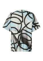 The TYPE-XV SOAR NY project 002 by A-POC ABLE ISSEY MIYAKE is a short-sleeve knit top featuring bold black curved lines and soft gray over light blue and white, shown flat on a white background.