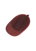 The TYPE-O CAP by A-POC ABLE ISSEY MIYAKE is a maroon adjustable hat with an oval woven mesh crown, solid brim, and a black adjustable strap at the back, shown from above.