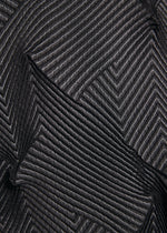 Close-up of TYPE-O 010-1 by A-POC ABLE ISSEY MIYAKE: black recycled polyester fabric with a chevron pattern of diagonal ribbed lines, creating a layered, three-dimensional effect.