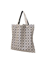 The BAO BAO ISSEY MIYAKE PRISM MATTE-2 tote bag is beige with black triangular lines, fits A4 documents, features two handles, a flexible futuristic design, and subtle grain texture, shown on a plain white background.
