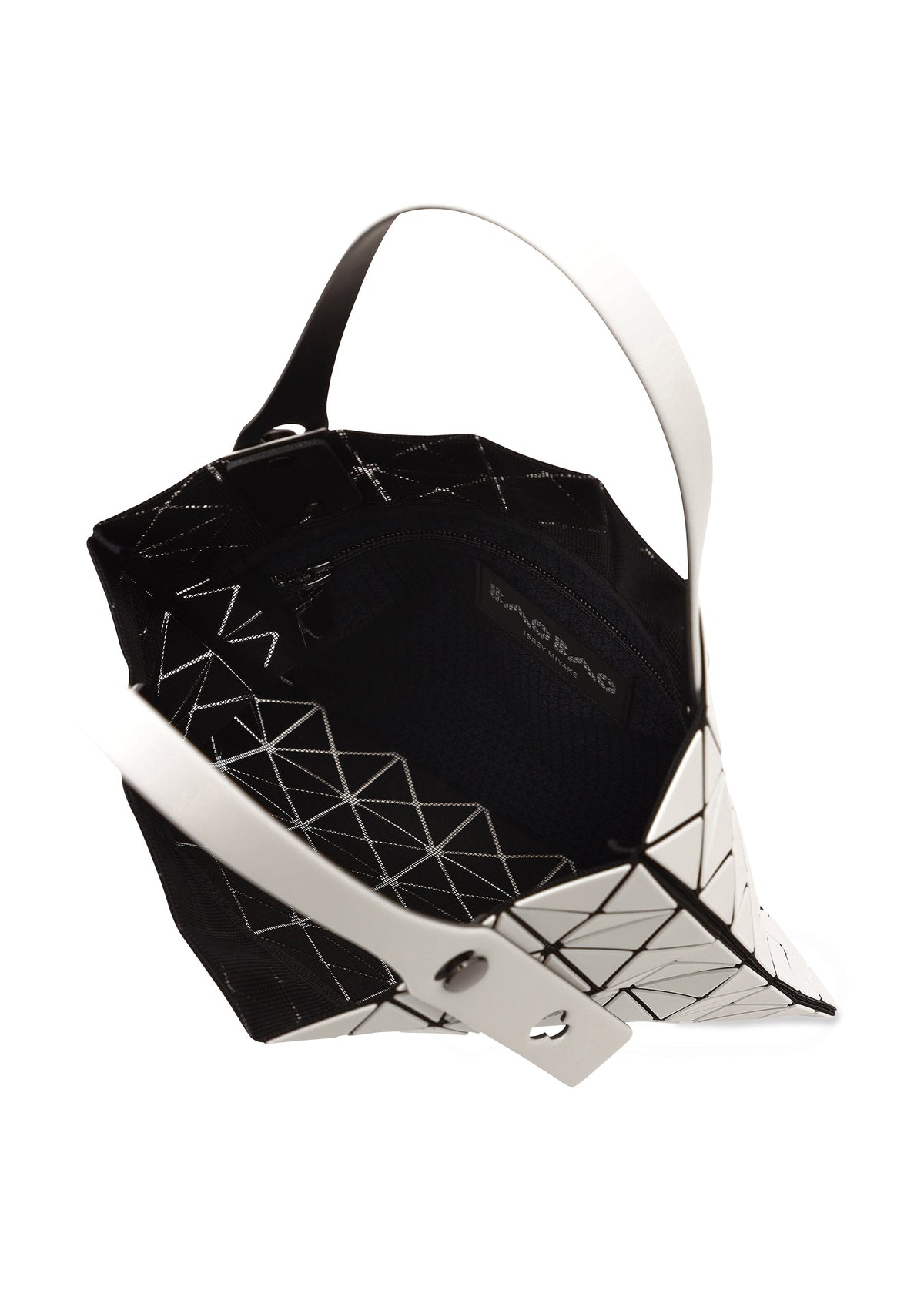 The PRISM MATTE-2 tote by BAO BAO ISSEY MIYAKE is shown open, displaying its black interior, a zippered pocket, and brand label. Its exterior has a striking black-and-white triangular pattern and white handle. view 6 of 8