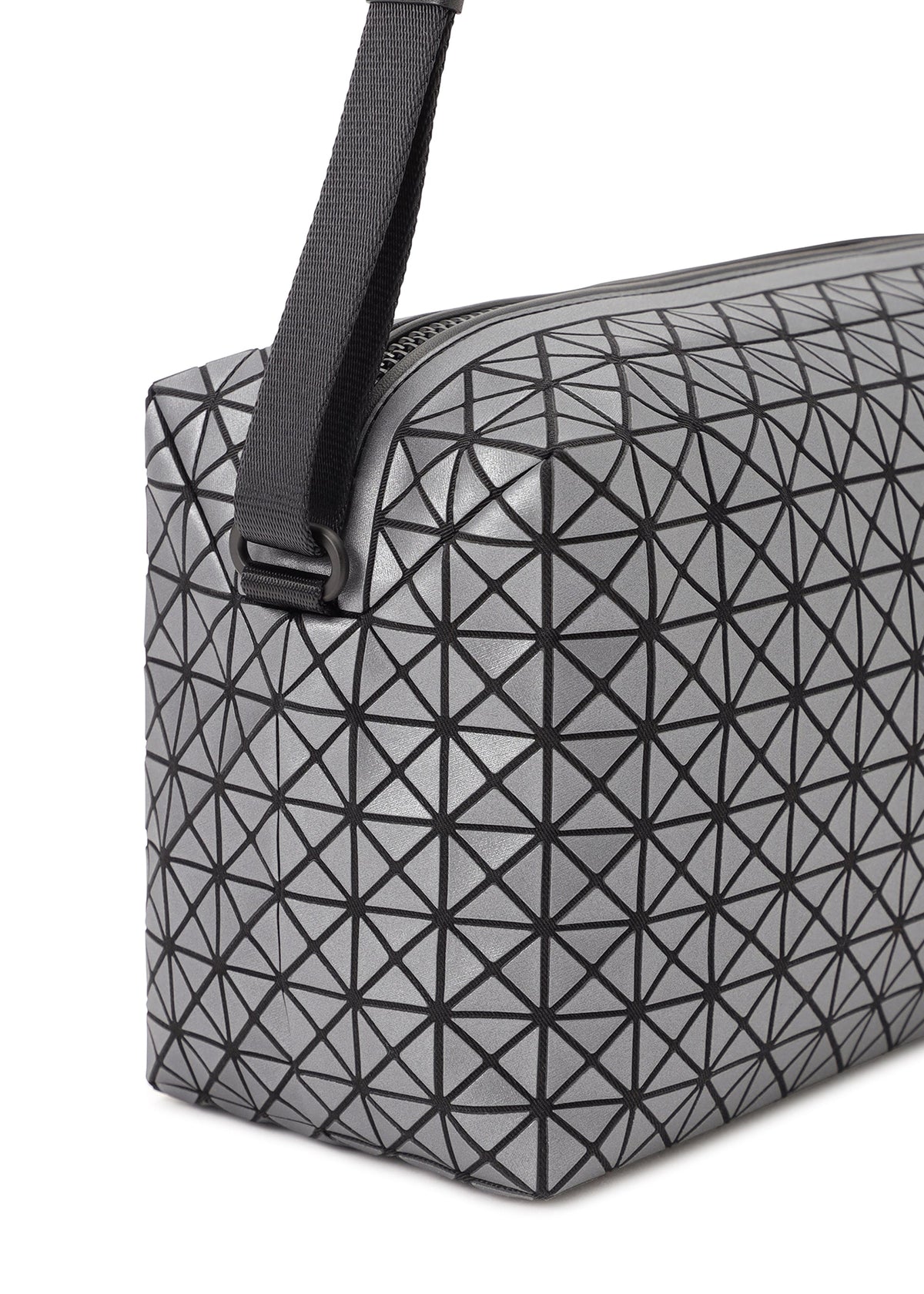 A close-up of the BAO BAO ISSEY MIYAKE SADDLE BAG REFLECTOR, featuring a gray geometric-patterned surface with black triangular lines and a thick black strap attached at the top corner. view 4 of 8