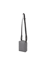 The BAO BAO ISSEY MIYAKE BEETLE REFLECTOR is a small, rectangular crossbody bag with reflective material, an adjustable black strap, and a geometric gray and black triangular grid pattern on the front.