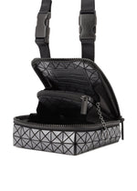 The BEETLE REFLECTOR by BAO BAO ISSEY MIYAKE is a small, boxy gray bag with a geometric triangle pattern and reflective finish, featuring black zipper with chain pull, adjustable black straps, and an open main compartment showing an inner zip pocket.