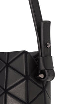 Close-up of the TONNEAU MATTE mini handbag by BAO BAO ISSEY MIYAKE, featuring black leather-like material, geometric triangular patterns, and a strap looped through a metal stud.
