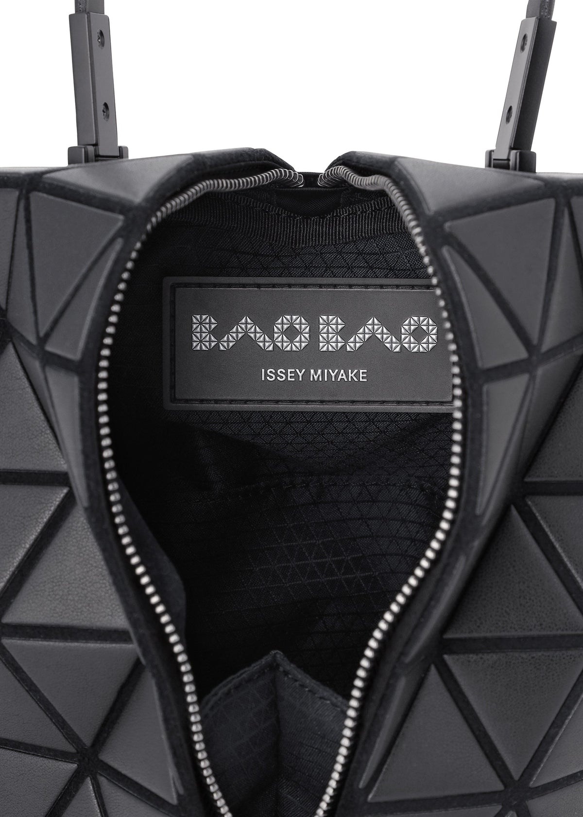 Close-up of the BAO BAO ISSEY MIYAKE TORSO handbag: a black equilateral triangle shape with a geometric pattern, open zipper, and visible inner label. view 6 of 8