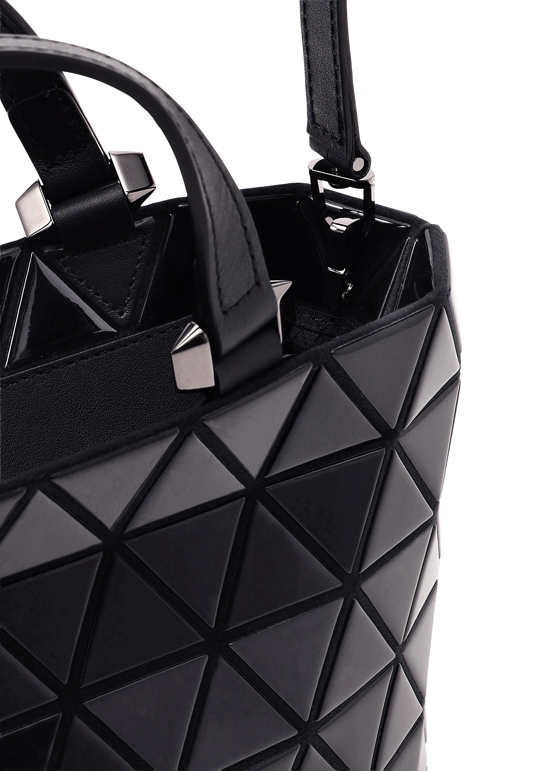 Zoomed view Close-up of the CRYSTAL GLOSS mini handbag by BAO BAO ISSEY MIYAKE in black cowhide leather, showcasing a geometric triangular pattern with silver square studs near the handle, set against a white background.