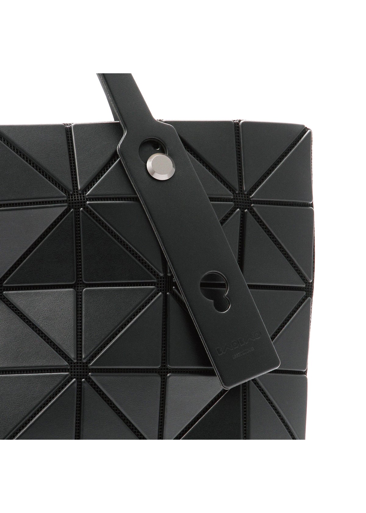 Close-up of the BAO BAO ISSEY MIYAKE ROCK MATTE handbag, featuring black geometric triangular panels, a strap with a round metal button and keyhole cutout, plus a gusseted bottom that fits a 13-inch laptop. view 5 of 8
