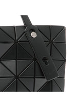 Close-up of the BAO BAO ISSEY MIYAKE ROCK MATTE handbag, featuring black geometric triangular panels, a strap with a round metal button and keyhole cutout, plus a gusseted bottom that fits a 13-inch laptop.