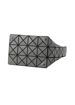 The BAO BAO ISSEY MIYAKE VALLEY bag is shown upright from the bottom, displaying a black geometric design with triangular shapes, four metal studs on each corner, and an adjustable handle for versatile carrying.
