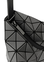 Close-up of the VALLEY handbag by BAO BAO ISSEY MIYAKE, featuring geometric black triangular panels, a visible zipper with branded pull, and a modern gusseted design that stands upright.