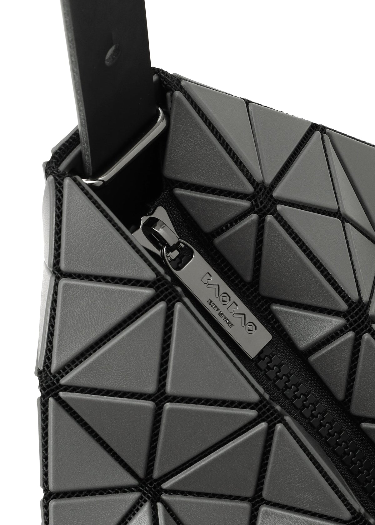 Close-up of the BAO BAO ISSEY MIYAKE VALLEY handbag featuring gray geometric triangular panels, an upright design, and a black partially open zipper with a metallic pull tab engraved with the brand name. view 6 of 8
