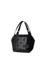 The BOSTON tote bag by BAO BAO ISSEY MIYAKE features a modern black design with geometric triangular patterns, two handles, and ample storage. Shown against a plain white background.