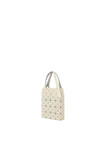 A beige PRISM PLUS mini tote bag by BAO BAO ISSEY MIYAKE, with geometric triangular patterns and two handles, shown against a plain white background.