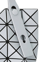 Close-up of a PRISM FROST tote bag by BAO BAO ISSEY MIYAKE, showing geometric light gray panels with black mesh, matte fabric-grain texture, and two overlapping straps with round cutouts and a snap button.
