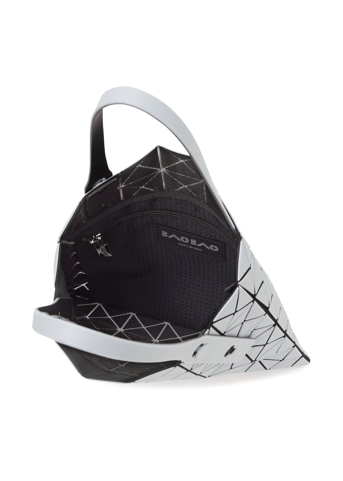 The PRISM FROST tote by BAO BAO ISSEY MIYAKE features a geometric white and black design, matte flexible triangular panels, a black interior, and an inner zip pocket labeled BAO BAO. The bag is partially open to show its details. view 7 of 9