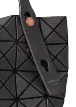 Close-up of the BAO BAO ISSEY MIYAKE PRISM DENIM tote bag featuring black geometric triangular panels, a textured strap with two copper buttons, subtle branding near the handle, and a secure zippered inside pocket.