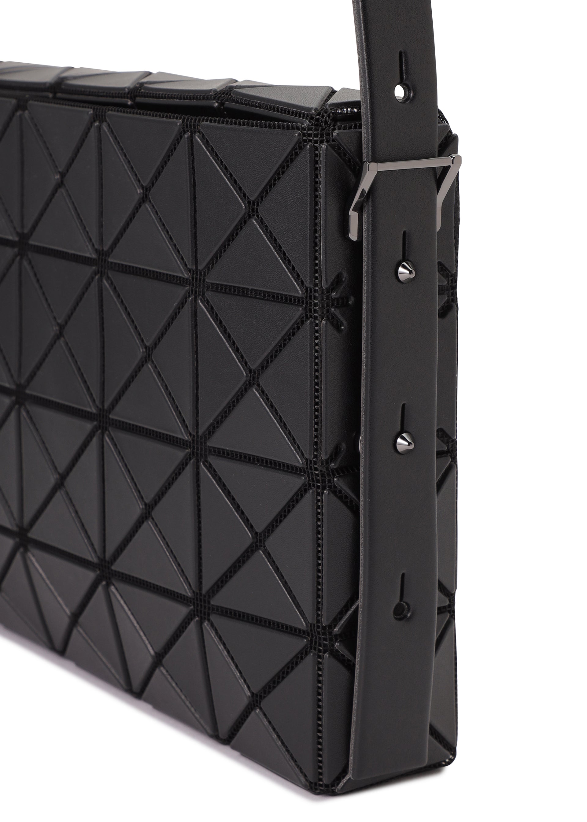 Zoomed view Close-up of the OBLONG handbag by BAO BAO ISSEY MIYAKE, featuring a black geometric triangular pattern, detailed stitching, and an adjustable strap with metal hardware and multiple holes.