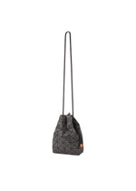 The WRING DENIM by BAO BAO ISSEY MIYAKE is a black geometric-patterned crossbody bag with triangular shapes, a long thin strap, and a small rectangular orange accent on the side, displayed on a plain white background.