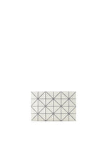 The LUCENT W COLOR by BAO BAO ISSEY MIYAKE is a rectangular, leather-like pouch with a white surface divided by thin black lines into geometric triangles, displayed on a plain white background.