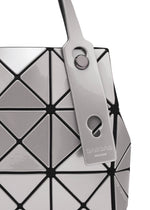 Close-up of the geometric, silver and black BAO BAO ISSEY MIYAKE CARAT handbag with metallic triangular panels, a matching tag on the handle, and an inner pocket for functionality.