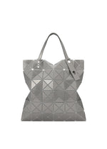 The LUCENT METALLIC tote by BAO BAO ISSEY MIYAKE features geometric triangular panels in shiny enamel for a modern, faceted silver look, finished with two handles and a matching silver tag. - STONE GRAY （no.09）