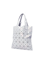The LUCENT METALLIC tote by BAO BAO ISSEY MIYAKE features geometric triangular panels in metallic silver enamel, two short handles, and a modern minimalist design, shown against a white background.