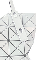 A close-up of the LUCENT METALLIC tote bag by BAO BAO ISSEY MIYAKE, featuring geometric white triangular panels, black outlines, a white strap with two round accents, and a subtle metallic finish.