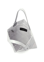 The LUCENT METALLIC by BAO BAO ISSEY MIYAKE is a white geometric tote with an angular, metallic look, featuring a spacious interior, zippered mesh inner pocket, black brand label, and two flat handles.