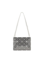 The LUCENT METALLIC by BAO BAO ISSEY MIYAKE is a rectangular silver shoulder bag with a geometric tile pattern and white adjustable strap, crafted from enamel for a metallic finish, shown on a plain white background. - STONE GRAY (no.17)