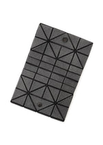 The BAO BAO ISSEY MIYAKE CARD WALLET is a rectangular mini wallet with a geometric gray design, black triangular lines, and two black snap buttons—perfect for a cash-less lifestyle and shown against a white background.